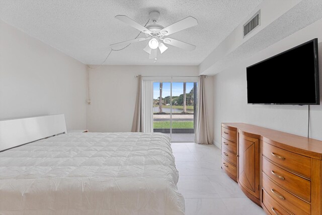 unfurnished bedroom with ceiling fan, access to exterior, and a textured ceiling