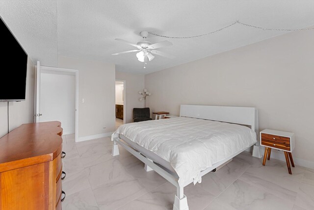 bedroom featuring a textured ceiling, ceiling fan, and connected bathroom