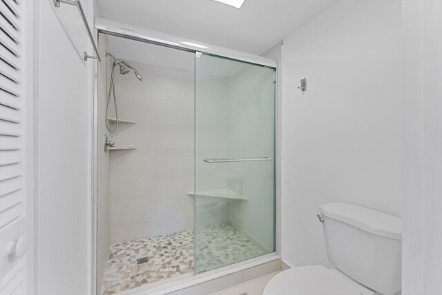 bathroom with an enclosed shower and toilet