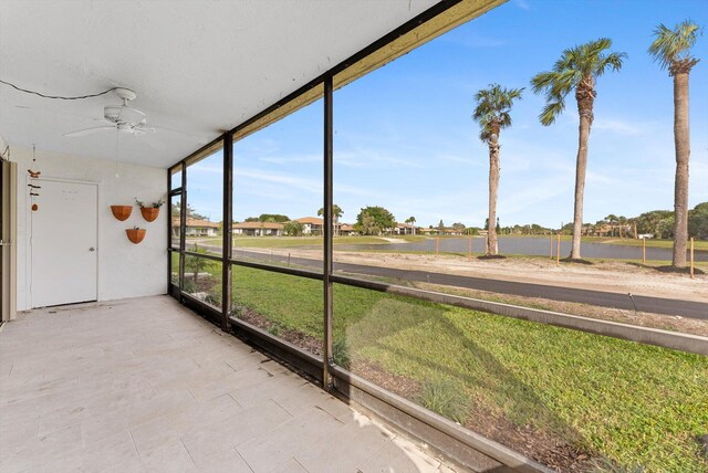 unfurnished sunroom with ceiling fan