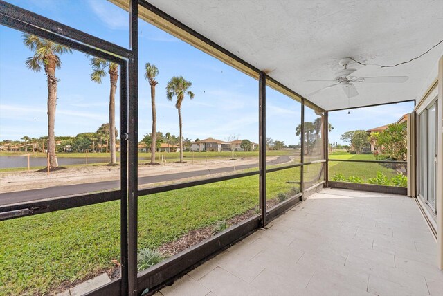 unfurnished sunroom with ceiling fan