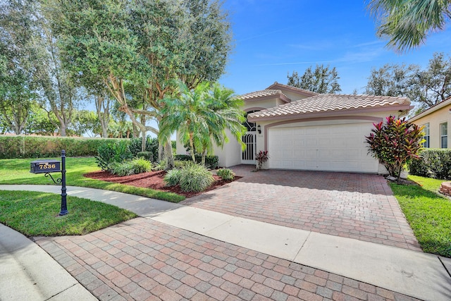 mediterranean / spanish-style home featuring a garage and a front lawn