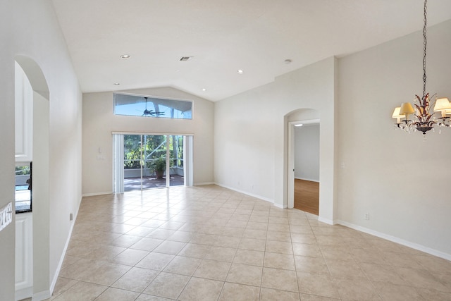 spare room with light tile patterned flooring, an inviting chandelier, and high vaulted ceiling