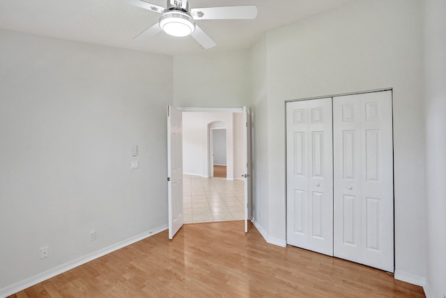 unfurnished bedroom featuring light wood-type flooring, ceiling fan, and a closet