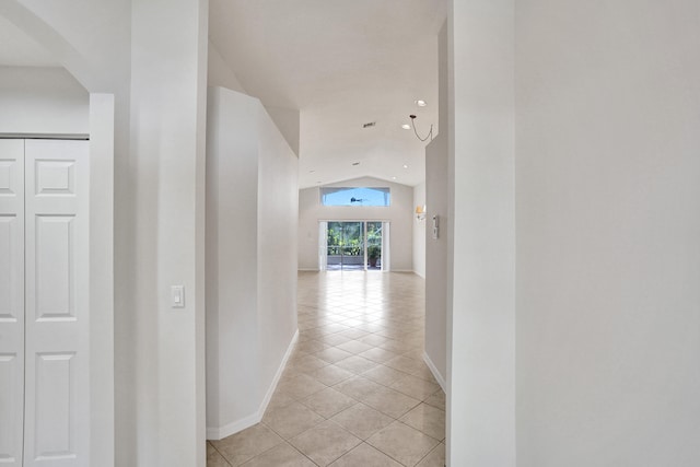 hallway featuring vaulted ceiling and light tile patterned floors