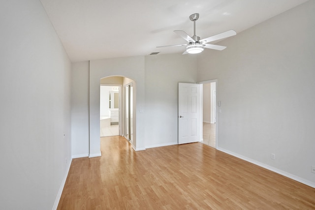 unfurnished room featuring light hardwood / wood-style floors, ceiling fan, and a high ceiling