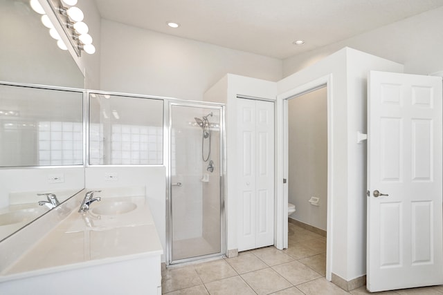 bathroom with walk in shower, vanity, tile patterned floors, and toilet