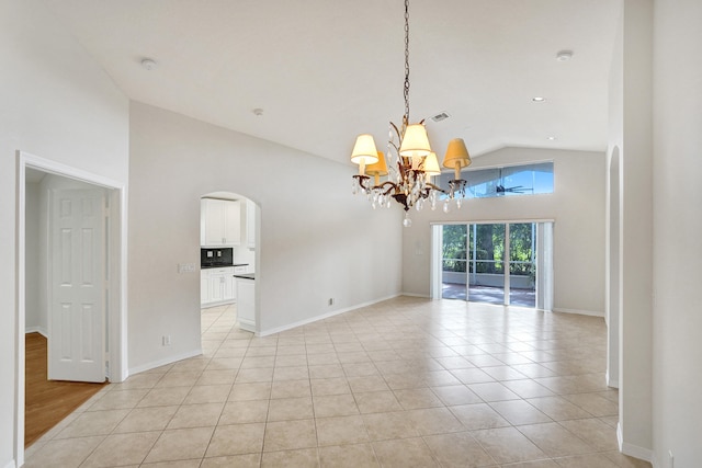 spare room with light tile patterned floors, an inviting chandelier, and high vaulted ceiling