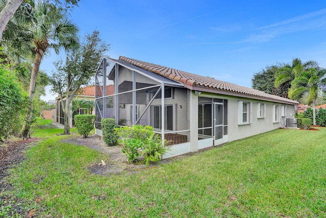 back of house with a lanai, central AC, and a yard