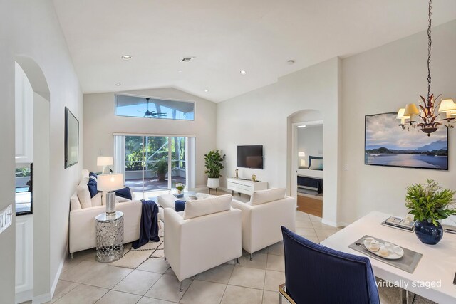 living room featuring arched walkways, light tile patterned floors, lofted ceiling, and a chandelier