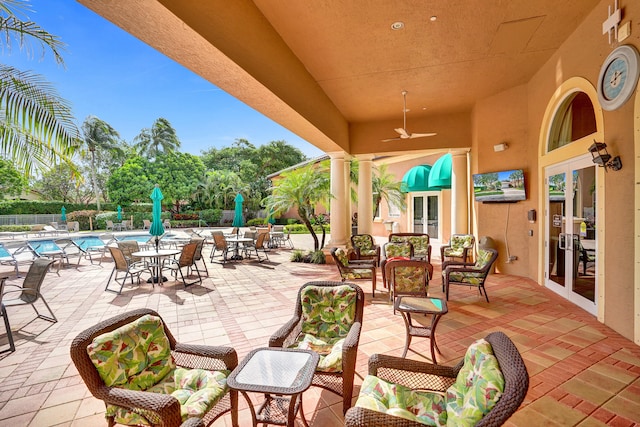 view of patio / terrace with a community pool, french doors, and ceiling fan