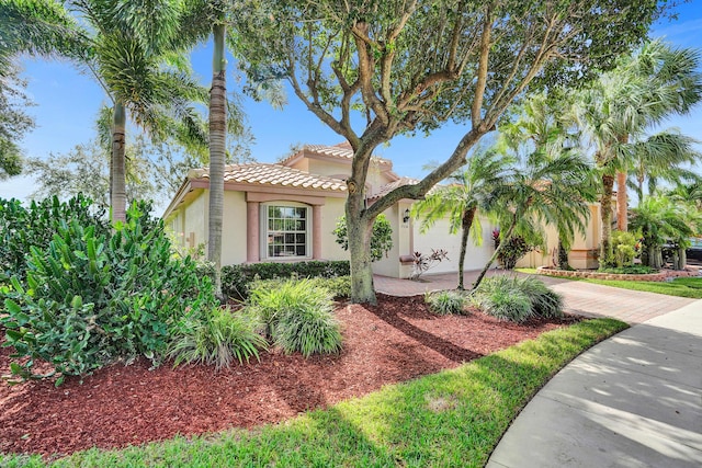 view of front of home featuring stucco siding, decorative driveway, an attached garage, and a tile roof