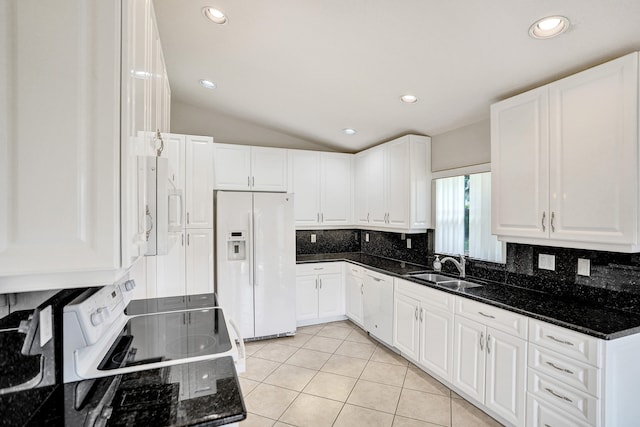 kitchen featuring white cabinetry, sink, white appliances, and dark stone countertops