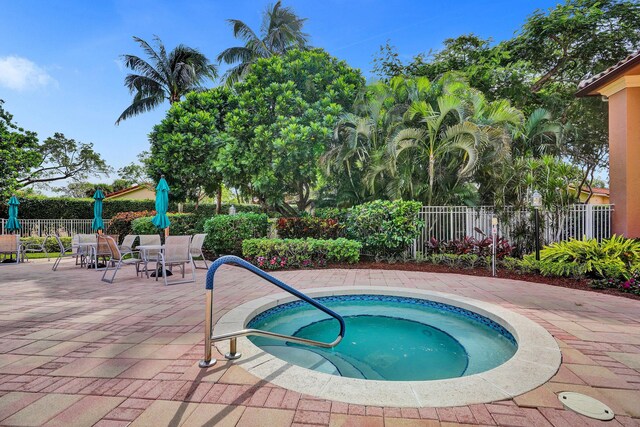 view of swimming pool with a hot tub, fence, a patio area, and outdoor dining area