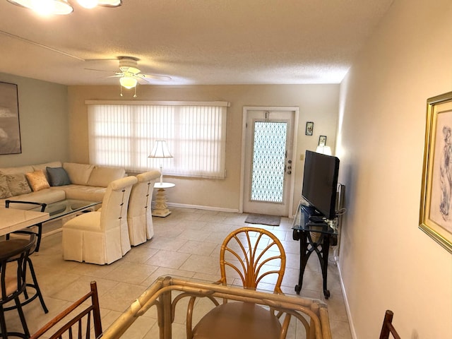 tiled living room with a textured ceiling and ceiling fan