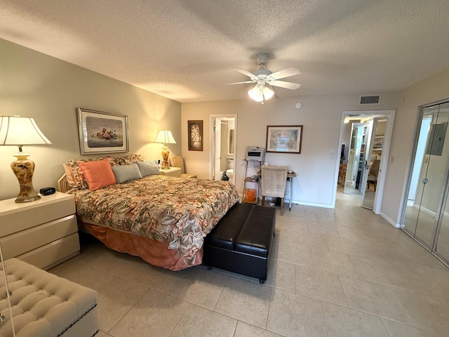 bedroom with a textured ceiling, ensuite bath, ceiling fan, and light tile patterned flooring