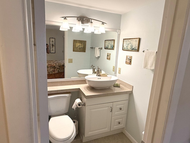 bathroom featuring toilet, vanity, and tile patterned flooring