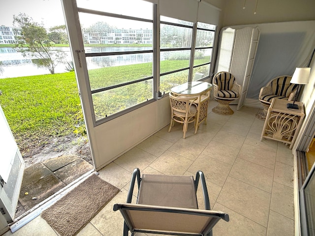 sunroom / solarium featuring a water view