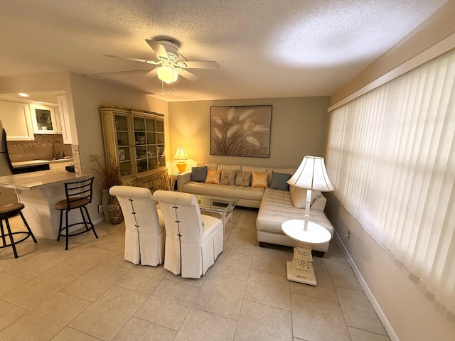 tiled living room with sink, ceiling fan, and a textured ceiling