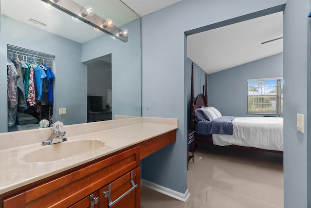 bathroom featuring tile patterned flooring, vanity, and lofted ceiling