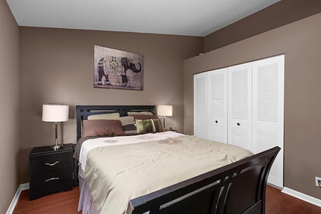 bedroom featuring a textured ceiling, a closet, dark wood-type flooring, and vaulted ceiling