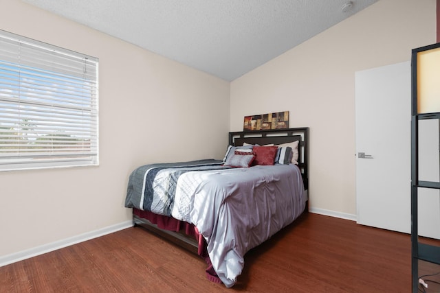 bedroom featuring a textured ceiling, dark hardwood / wood-style floors, and vaulted ceiling