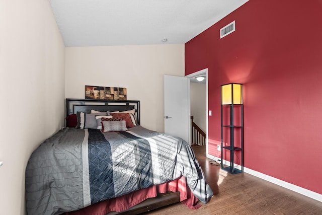 bedroom featuring hardwood / wood-style flooring and high vaulted ceiling