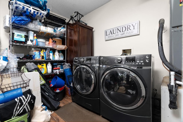 laundry room with washer and clothes dryer, a textured ceiling, and hardwood / wood-style flooring