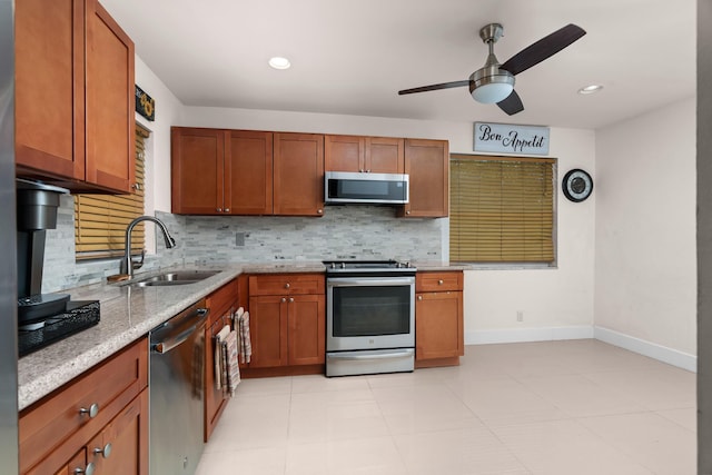 kitchen featuring sink, ceiling fan, light stone countertops, tasteful backsplash, and stainless steel appliances