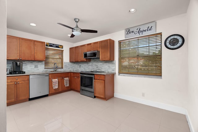 kitchen featuring decorative backsplash, sink, ceiling fan, and stainless steel appliances