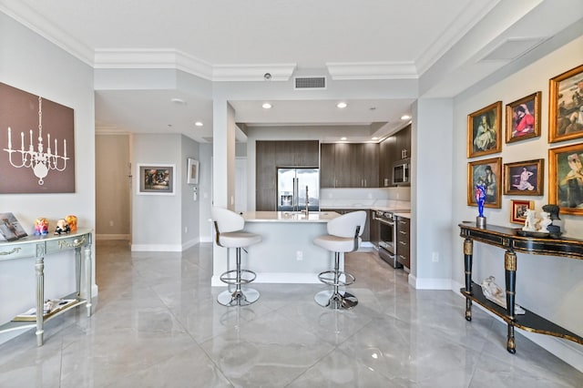 kitchen with dark brown cabinetry, stainless steel appliances, crown molding, a breakfast bar area, and a kitchen island with sink