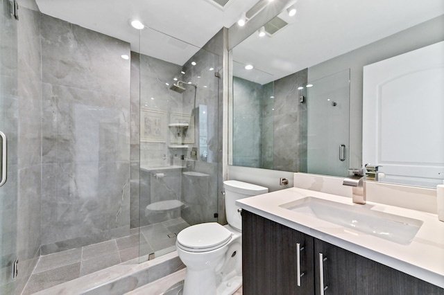 bathroom with vanity, toilet, and a shower with door