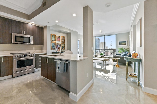 kitchen with a center island with sink, crown molding, sink, dark brown cabinetry, and stainless steel appliances