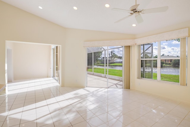 tiled spare room with ceiling fan, a water view, and vaulted ceiling