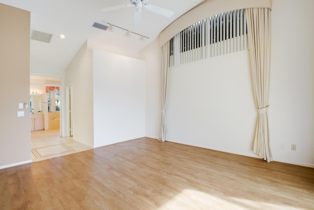 empty room with ceiling fan, rail lighting, and light hardwood / wood-style floors