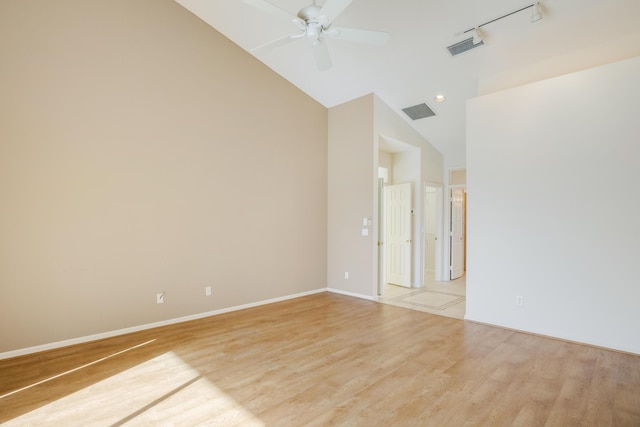 empty room with ceiling fan, vaulted ceiling, and light wood-type flooring