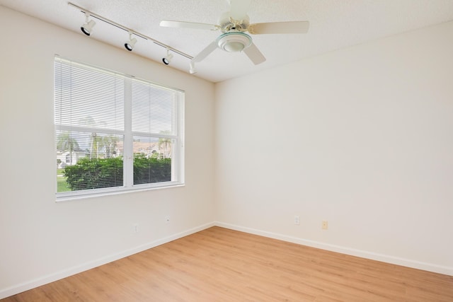 unfurnished room featuring ceiling fan, light hardwood / wood-style floors, and a textured ceiling