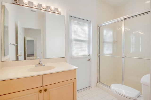 bathroom featuring tile patterned floors, toilet, vanity, and walk in shower