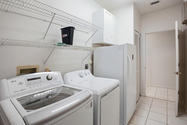 washroom with cabinets, light tile patterned flooring, and washing machine and dryer