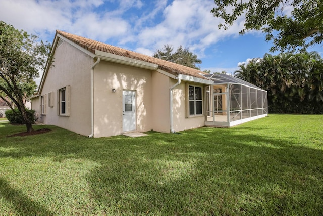 back of property featuring a lawn and a lanai