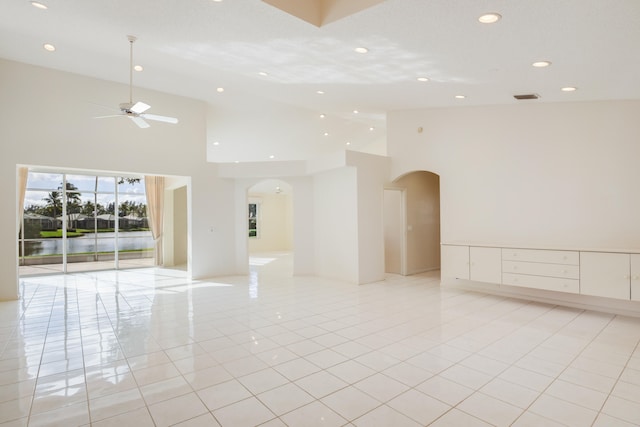 tiled spare room with a high ceiling and ceiling fan