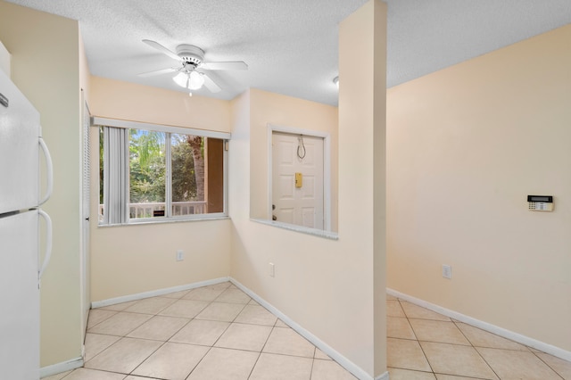 spare room featuring light tile patterned flooring, a textured ceiling, and ceiling fan