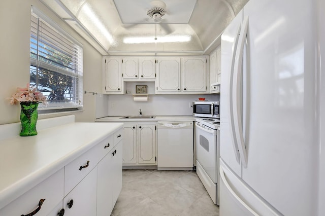 kitchen featuring white cabinetry, white appliances, and sink