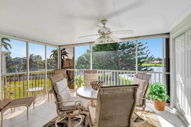 sunroom / solarium featuring a water view and ceiling fan