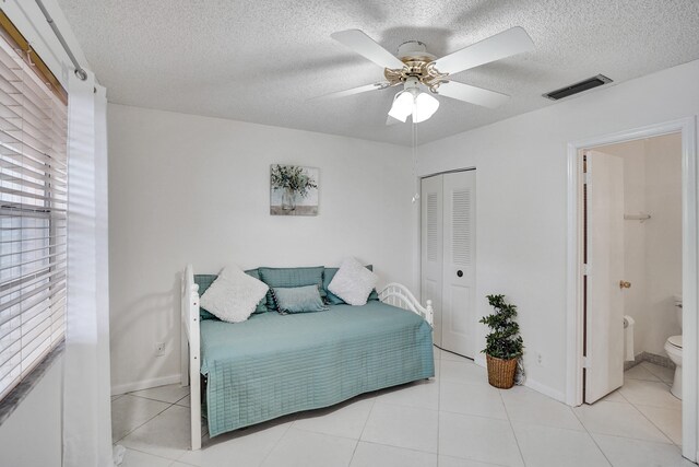 1260 NW 20th Ave Unit 203, Delray Beach, FL 33445 - bedroom with a closet, ceiling fan, visible vents, a textured ceiling, and ensuite bathroom