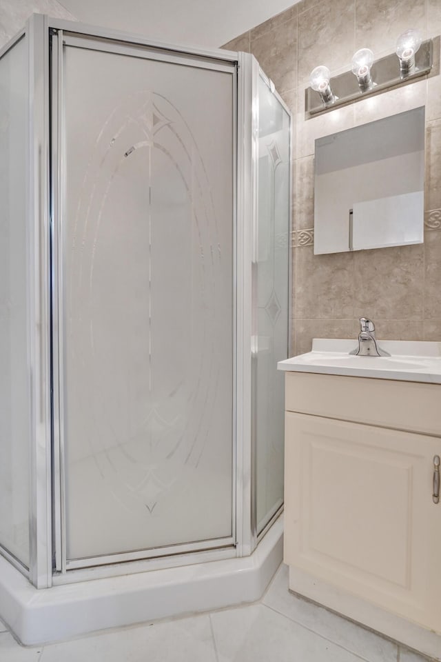 1260 NW 20th Ave Unit 203, Delray Beach, FL 33445 - bathroom featuring vanity, tile patterned flooring, a stall shower, and tile walls