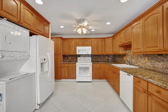 1260 NW 20th Ave Unit 203, Delray Beach, FL 33445 - kitchen featuring white appliances, decorative backsplash, a sink, stacked washing maching and dryer, and a ceiling fan