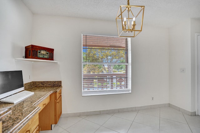 1260 NW 20th Ave Unit 203, Delray Beach, FL 33445 - unfurnished dining area featuring an inviting chandelier, a textured ceiling, light tile patterned floors, and baseboards