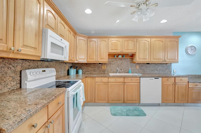 kitchen featuring a textured ceiling, white appliances, light brown cabinetry, and sink