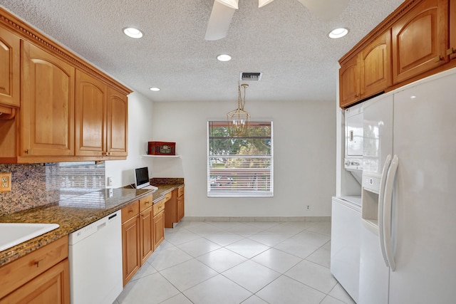 1260 NW 20th Ave Unit 203, Delray Beach, FL 33445 - kitchen featuring stacked washer and dryer, white appliances, baseboards, visible vents, and a textured ceiling